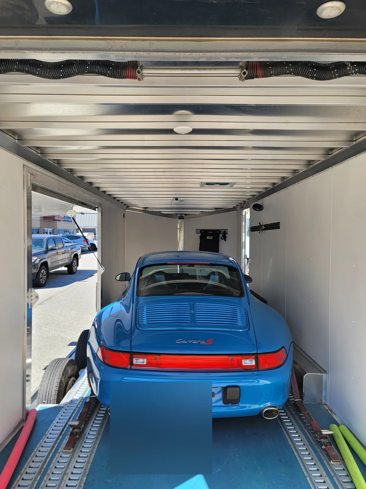 Blue Porsche 911 (993) secured inside a Coast2Coast enclosed auto transport trailer.